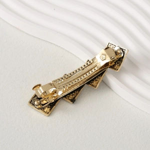 Detailed view of the textured gold geometric hair clip with spring closure mechanism