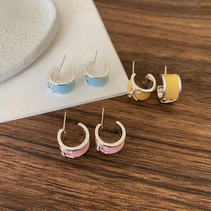 Macro detail view of sweet enamel bow stud earrings in pastel blue yellow and pink colors