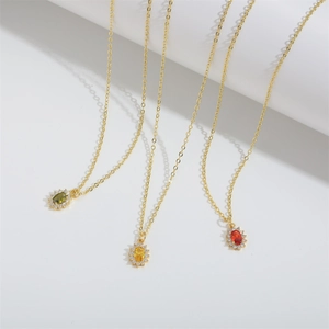 Three gold sunflower necklaces with red, yellow, and green zircon pendants on white background