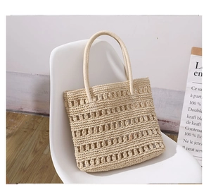 Detail of hollow-out straw handbag on white chair showing natural woven texture