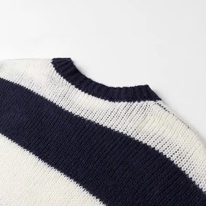 Close-up of the ribbed crew neck and soft knit texture of the black and white striped sweater