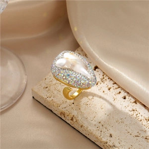 Macro shot of Baroque pearl ring with iridescent crystals on textured stone base