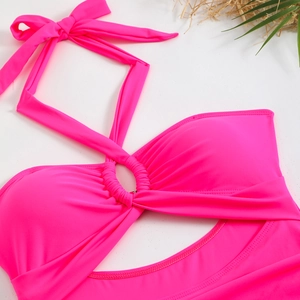 Dettaglio del costume da bagno rosa acceso con scollo all'americana e anello centrale