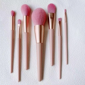 Detailed flat lay of 7 pink makeup brushes with rose gold ferrules on white background