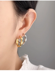 Close-up of model wearing wavy gold and silver S925 sterling silver ear cuffs