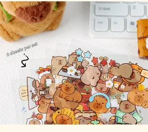 Close-up of 6-piece waterproof Capybara stickers set on desk with cute plush toy
