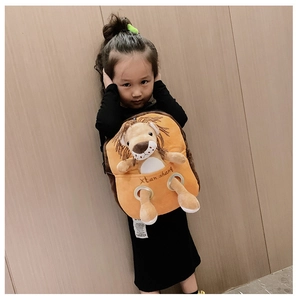 Toddler modeling a cute plush orange lion backpack with soft 3D ears and embroidery