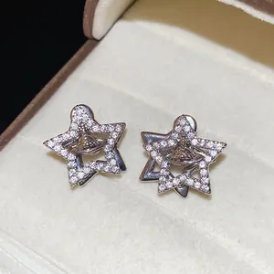 Silver star earrings with sparkling zircon planet orb pendants in a jewelry box