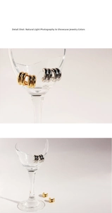 Macro detail shot of minimalist gold and silver double C-shaped earrings with mirror finish