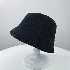 Texture détaillée du tissu plissé noir sur un chapeau bob de style japonais épuré