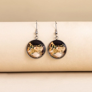 Close-up of silver drop earrings featuring Klimt The Kiss art under a glass dome