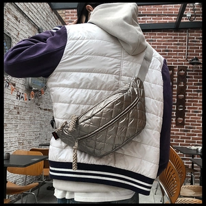 Champagne gold quilted puffer fanny pack styled as a crossbody bag on a model's back