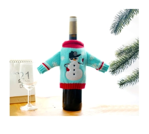 Close-up of a blue knitted Christmas wine bottle cover with a snowman and snowflake design