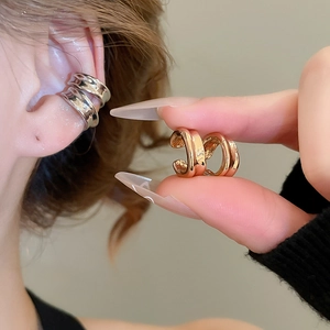 Detailed view of gold and silver double-hoop polished cuff earrings without piercings