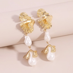 Detail of golden ginkgo leaf earrings with dangling baroque pearls and brushed texture
