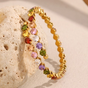 Detail of 18K gold plated stainless steel bracelet with rainbow zircon stones on stone