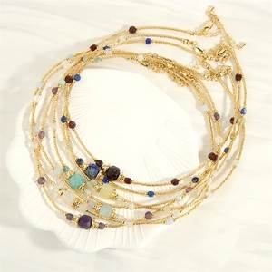 Lapis and amazonite beaded necklace with gold accents on a white shell tray