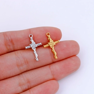 Creative rose cross pendant in gold and silver finish shown held by hand on white background