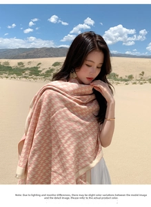 Fashionable pink and beige houndstooth scarf with tassels shown in outdoor desert setting