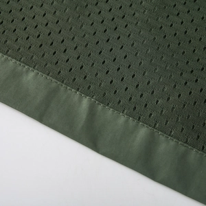 Close-up of breathable dark green honeycomb mesh fabric and durable seam stitching