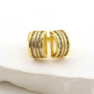 Detailed view of gold multi-layer ring with sparkling clear stones on a natural stone base