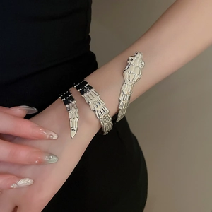 Macro detail of silver wrap-around snake bone bracelet with mirror finish on wrist