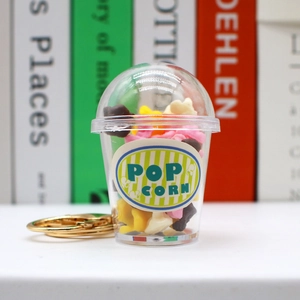 Macro view of a realistic miniature popcorn cup keychain with colorful corn kernels