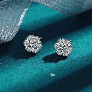 Macro detail of D-color moissanite floral stud earrings in 925 sterling silver on green velvet