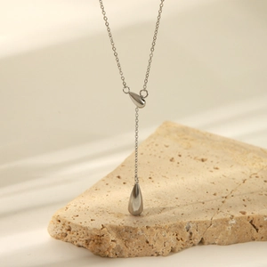Elegant silver stainless steel Y-necklace with teardrop pendant on stone background