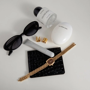 Close-up of luxury gold ear cuffs and vintage watch styled with high-end accessories