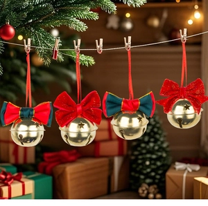 Close-up of golden Christmas bells with red velvet bows hanging on a rustic hemp rope