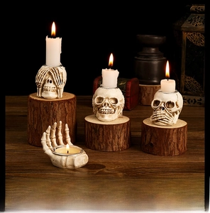 Gothic skull tea light holder set with skeletal hand on rustic wood for Halloween decor