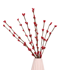 Artificial red berry stems with glossy fruits in a pink vase for Christmas decoration