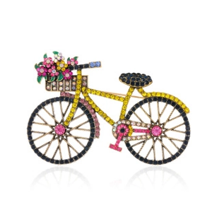 Macro view of golden bicycle brooch inlaid with sparkling yellow rhinestones and floral basket