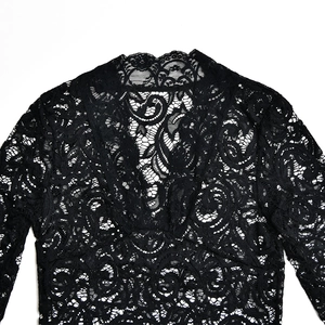 Close-up of intricate black hollow-out lace neckline on a sexy deep V-neck dress
