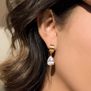 Close-up of 18K gold-plated stainless steel earrings with sparkling pear-cut zircon on model