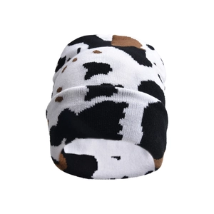 Detailed view of the cow print pattern and soft knit texture on the warm beanie hat