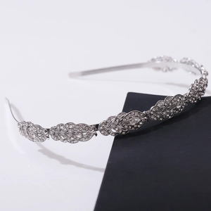 Detailed view of silver metal leaf-shaped headband with sparkling rhinestones decoration