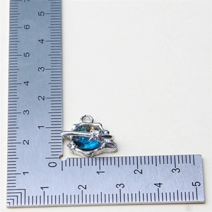 Macro view of blue gradient Saturn pendant charm with silver border and white stones