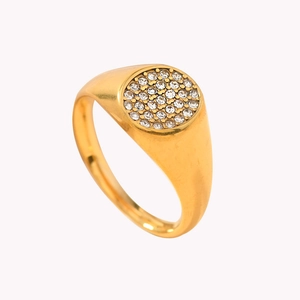 Gold plated stainless steel ring with a round cluster of sparkling crystals on a white base
