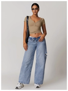 Detail of khaki slim-fit cropped tee with V-neck buttons and ripped wide-leg jeans