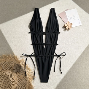 Flat lay of a sexy black one-piece swimsuit with V-neck, cut-outs, and side-tie details