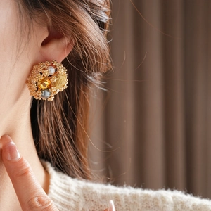 Gros plan de boucles d'oreilles vintage en forme de fleur avec perles et gemmes