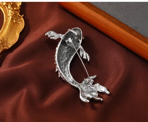 Macro detail of silver koi fish brooch back showing sturdy pin clasp and fin texture