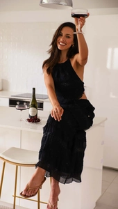 Detail of black halter backless top and tiered ruffle skirt with pleated texture fabric