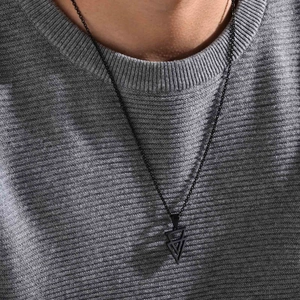 Men's black geometric triangle pendant necklace shown on model with grey sweater