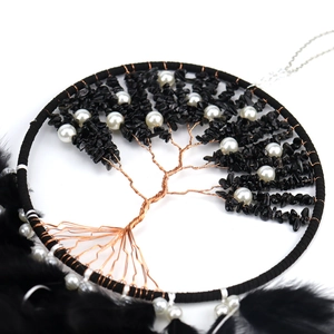 Macro detail of Tree of Life dream catcher with black crystal stones and feathers