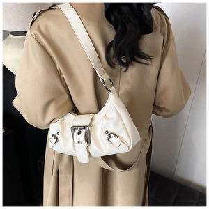Detail of cream white faux leather shoulder bag with vintage silver metal buckles