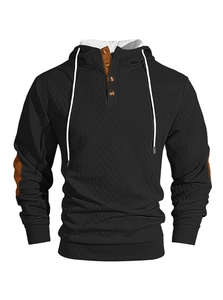 Détail macro du sweat à capuche gaufré noir pour hommes avec boutons et coudières marrons