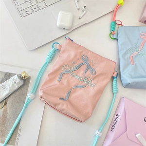 Détail de la broderie de nœuds et du texte Sarakka sur les sacs en toile roses